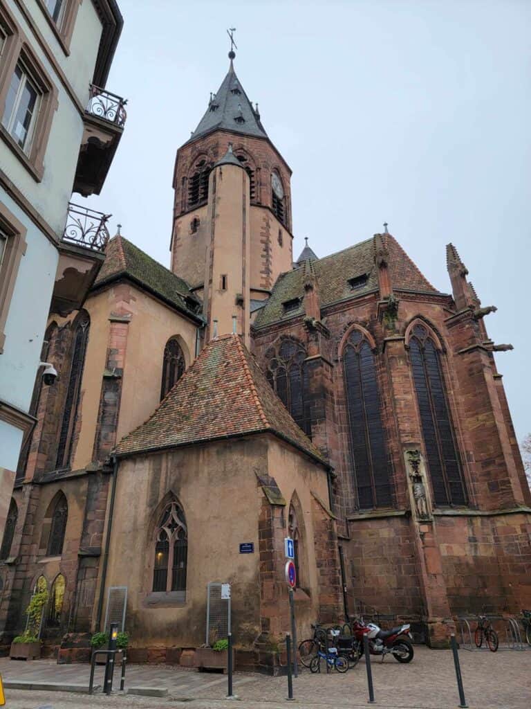 A medieval church with a spire, tall windows and gargoyles