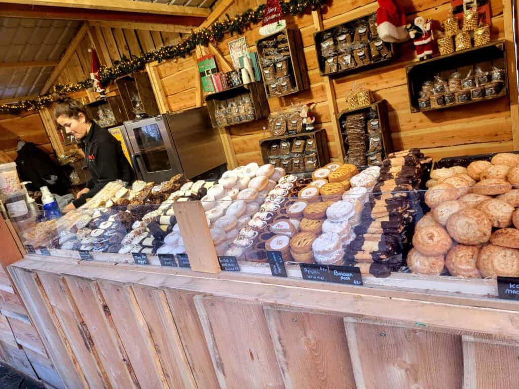 A wooden stall with rows of pastries