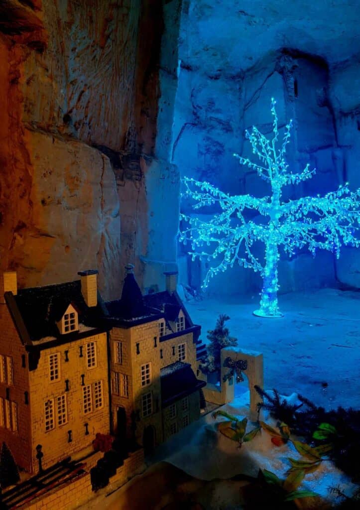 A model of a villa with a blue illuminated tree behind