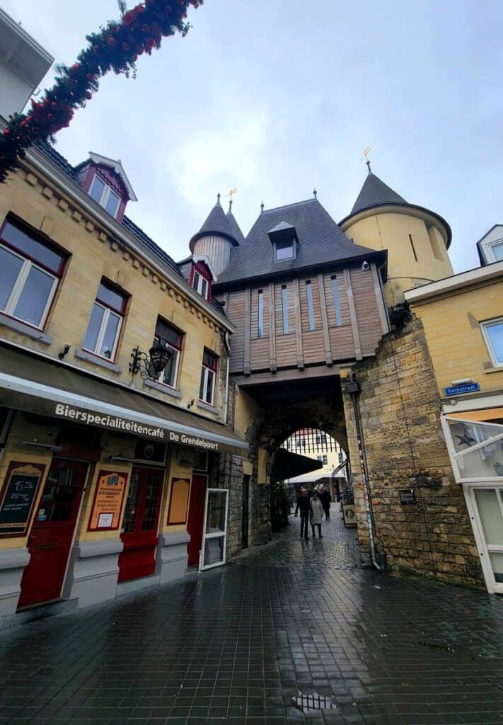 An old city gate with towers above and a cobblestone street running through it