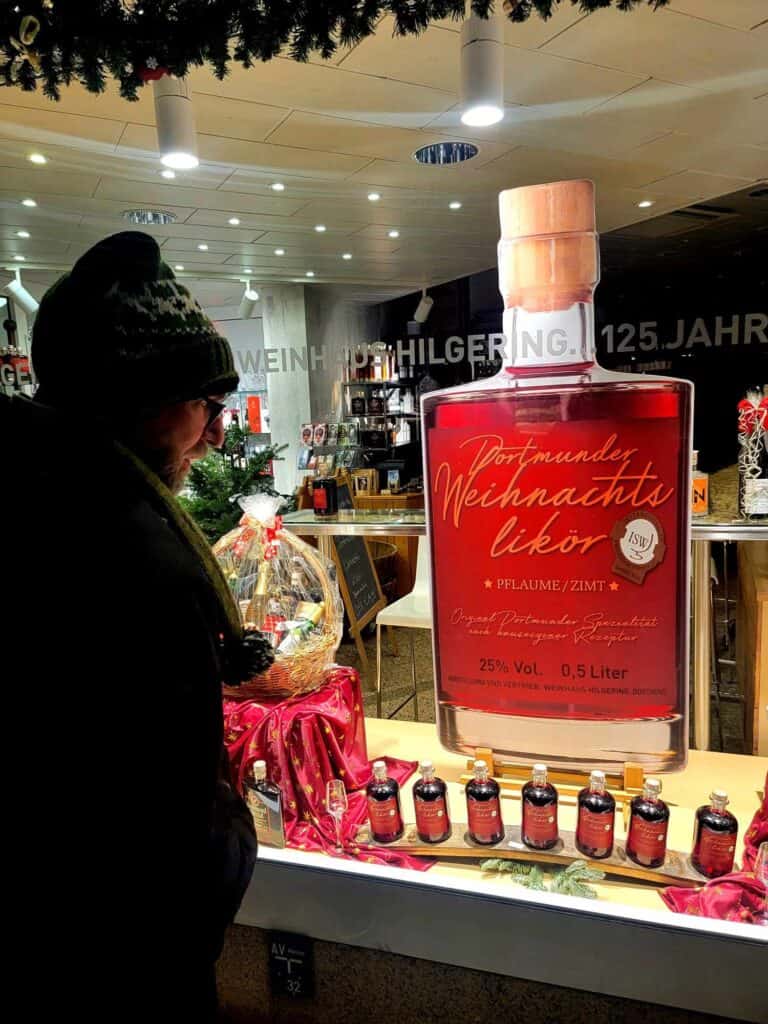 A man looking at a window display selling Weihnachts likor