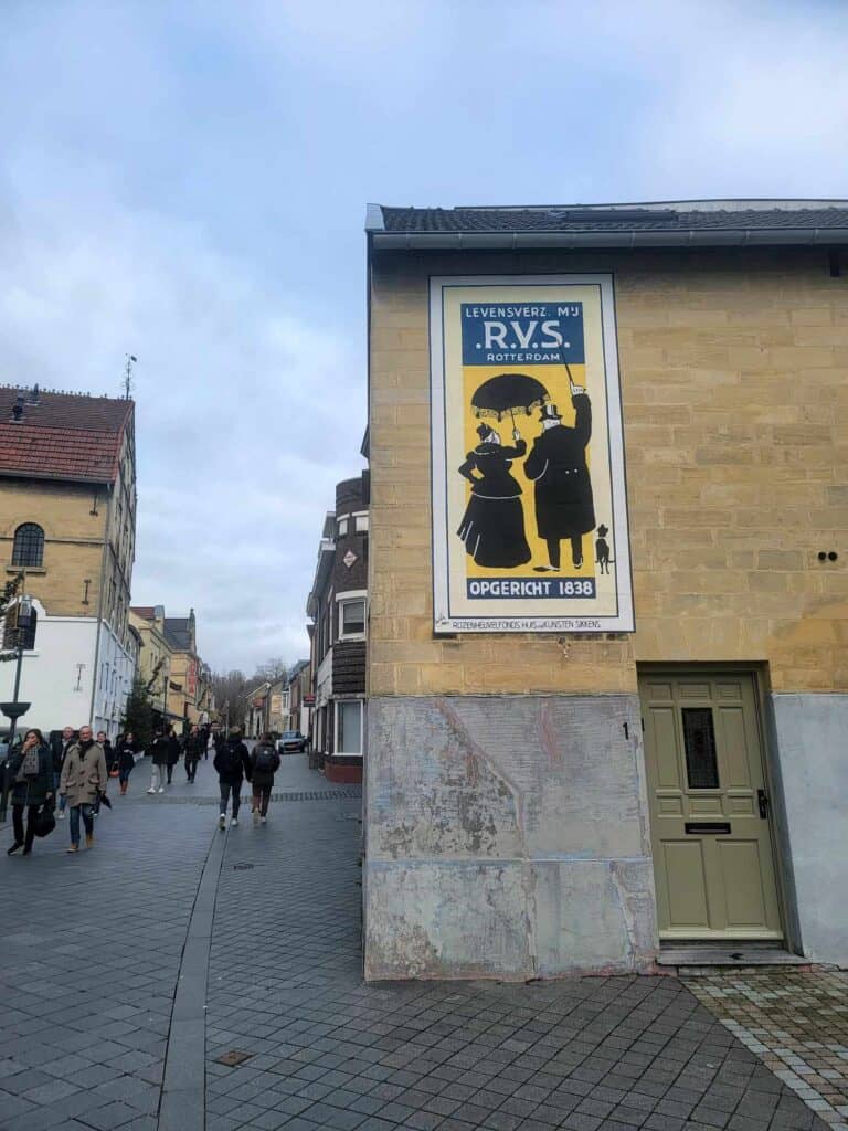 A street with a building with an old advertisement on the side