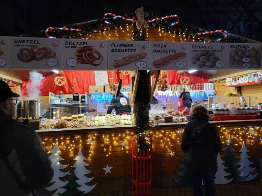 A food booth selling pretzels, flambée baguettes, and other foods