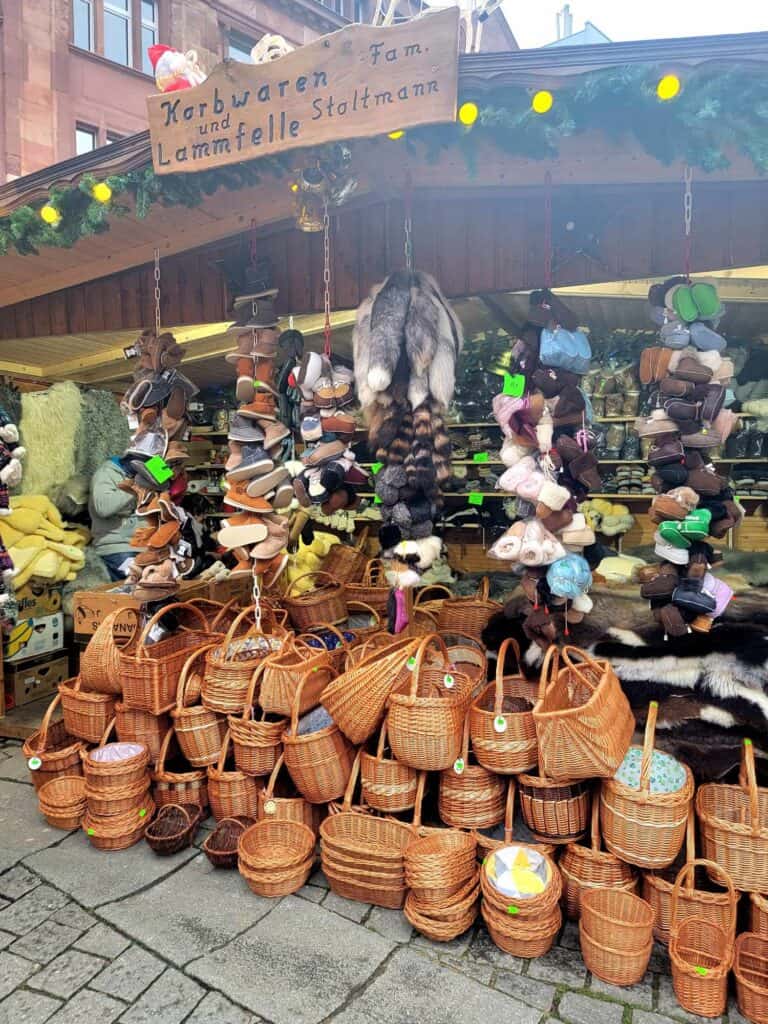 A market stall with a huge pile of woven baskets, and leather slippers hanging