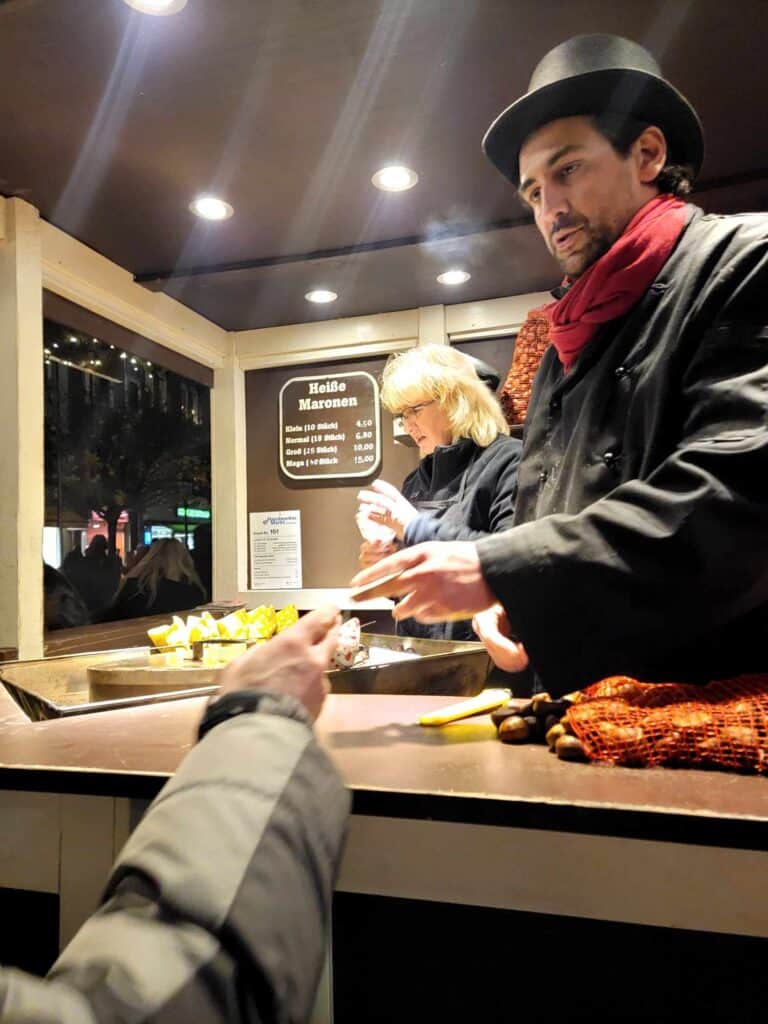 A man in a silk tophat selling roasted chestnuts