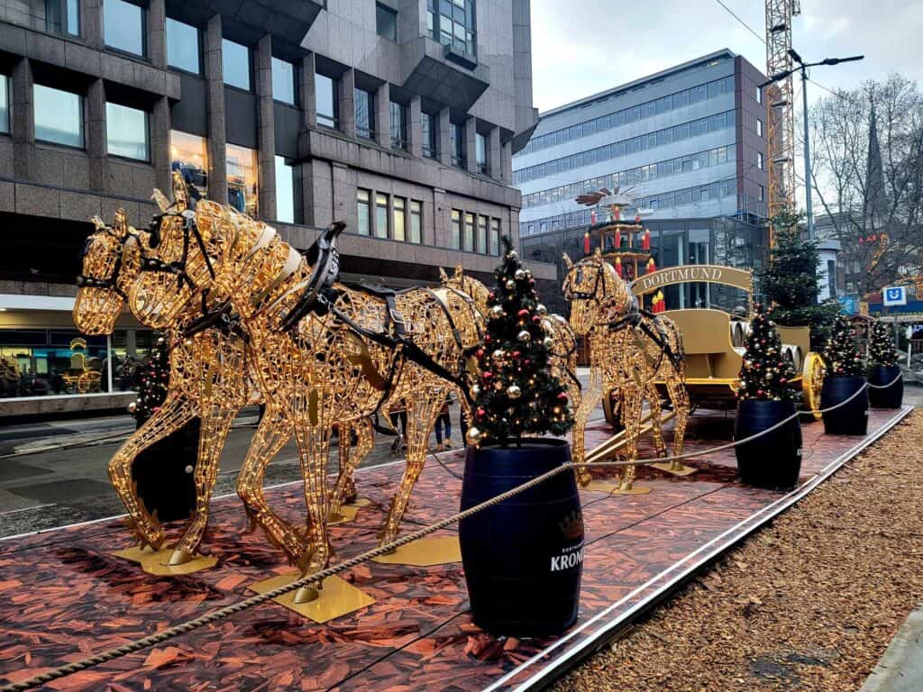 Horses pulling a wagon filled with beer barrels, all made of golden lights