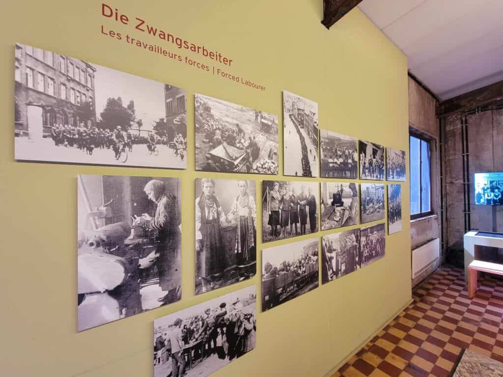 Black and white photos of male and female forced laborers on the wall