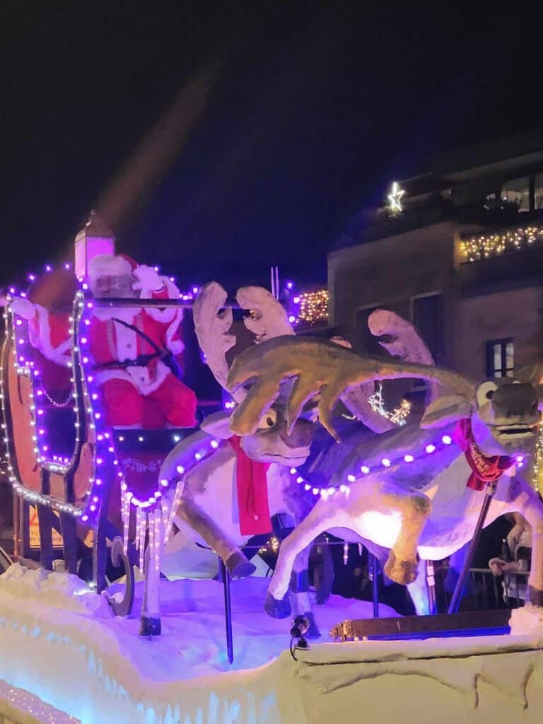 A Santa in a red and white suit in a sleigh