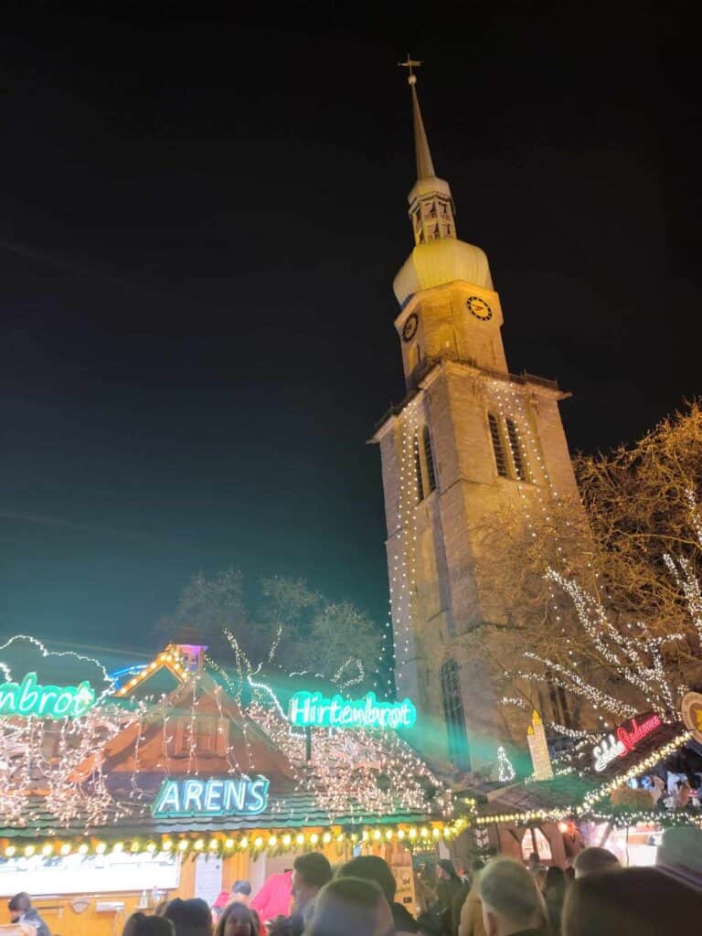 A church at night with lit market stalls underneath