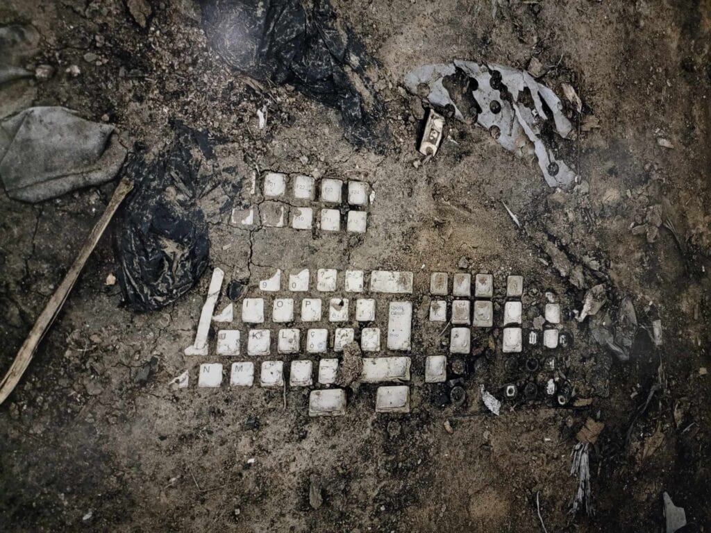 A keyboard buried in the dirt 