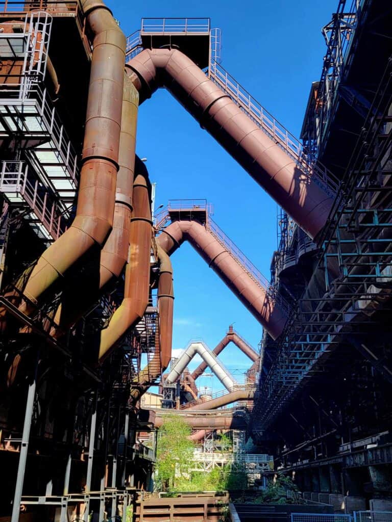 Large metal pipes lined in arches against a blue sky