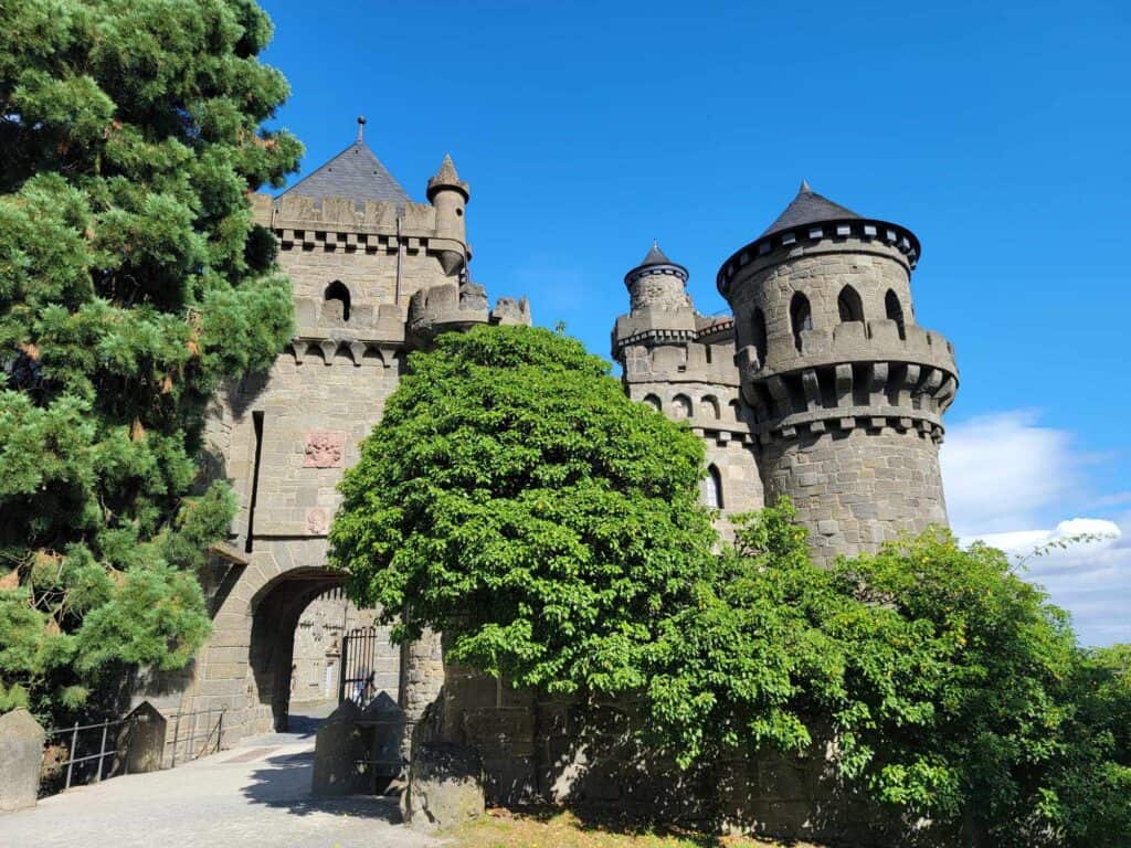 Trees in front of a castle with a gate