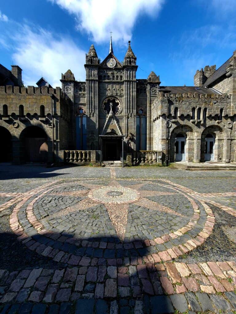 A view of a castle courtyard with a compass rose in stone mosaic