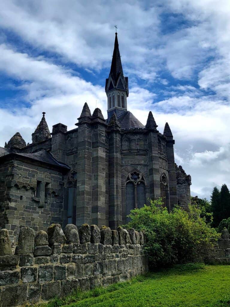 A stone wall with a romantic castle with many towers and turrets