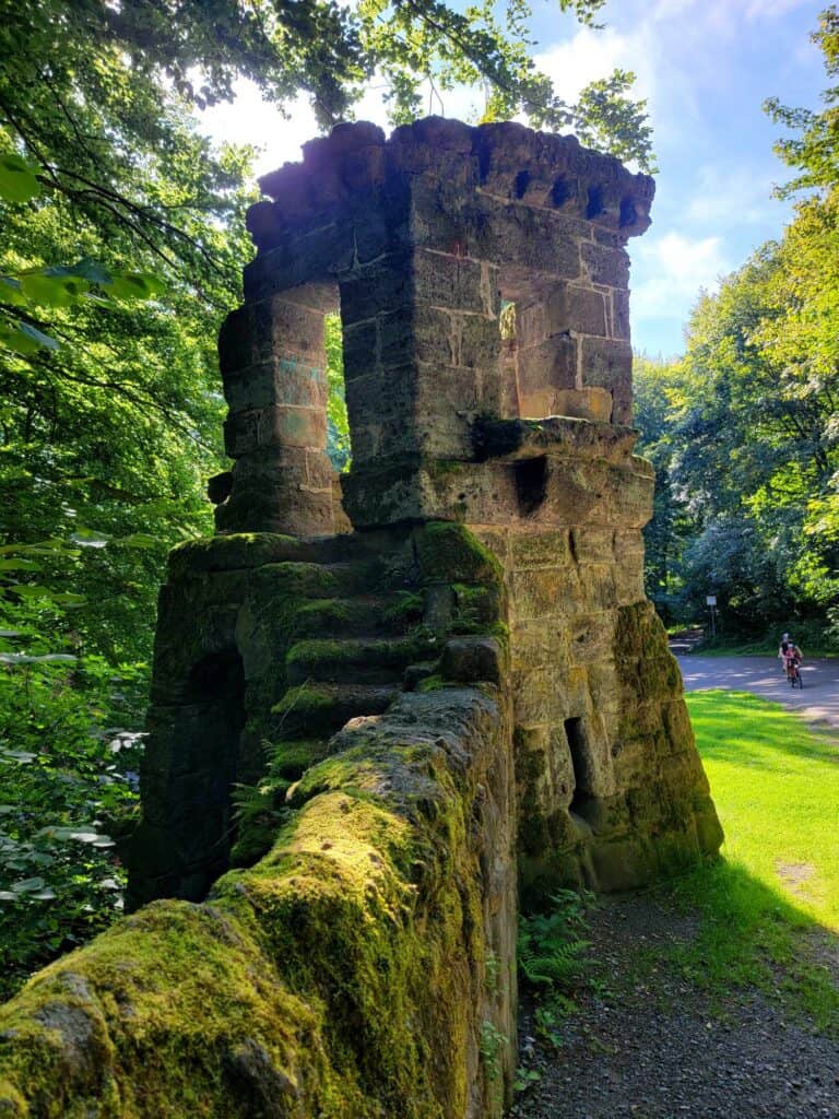 A mossy wall and stone steps lead to a guard house