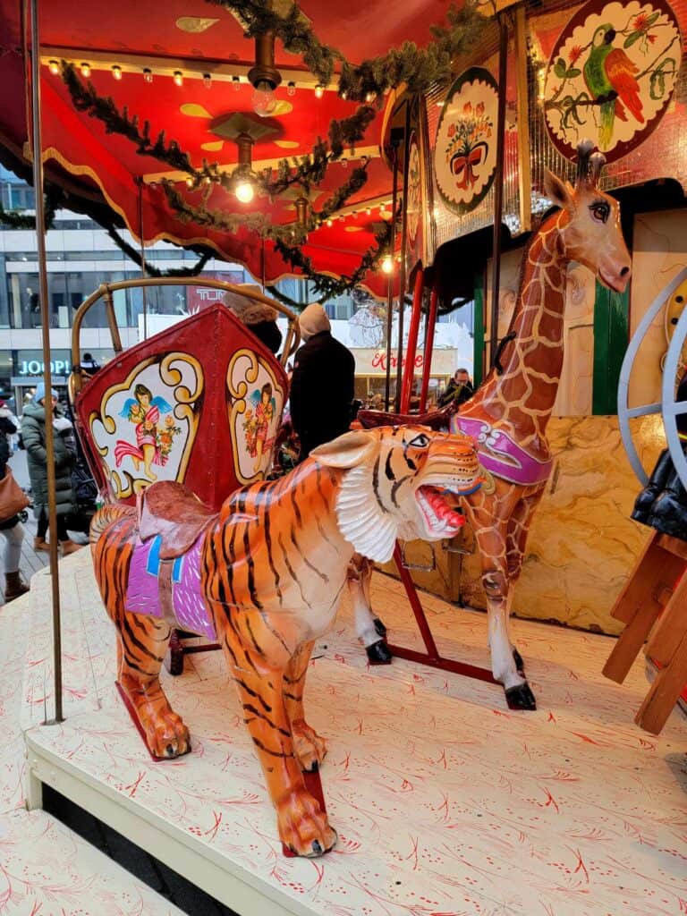 An old fashioned carousel with a tiger and giraffe