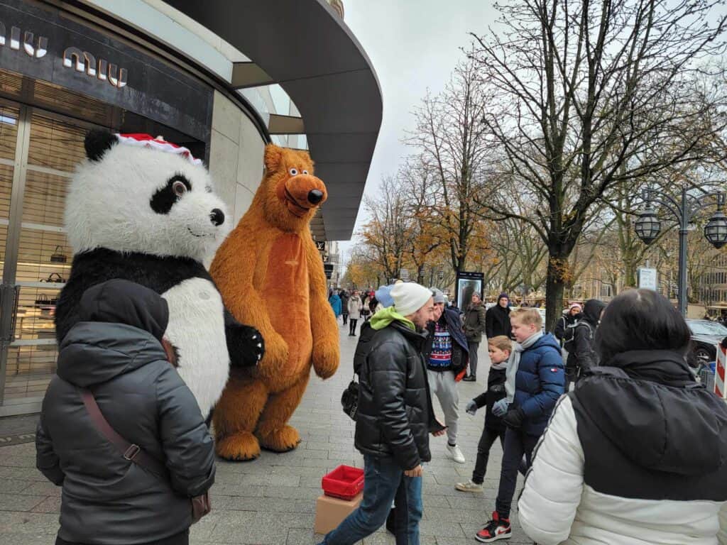 Two people in large bear costumes (panda and grizzly)