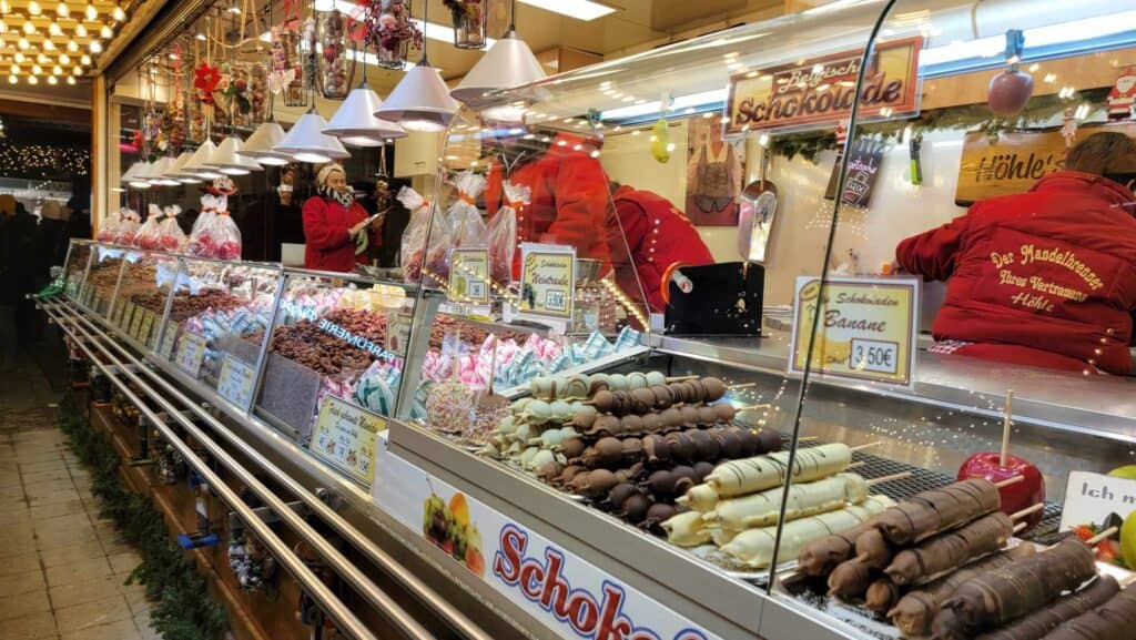 A stall with a glass case filled with chocolate covered fruit