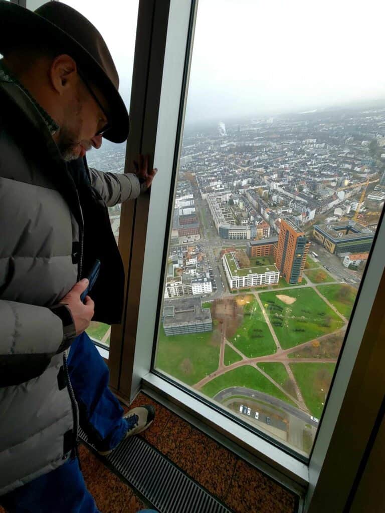 A man looking out of a window of the Rheinturm tower