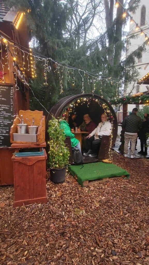 People sitting inside a giant wine barrel at a small table