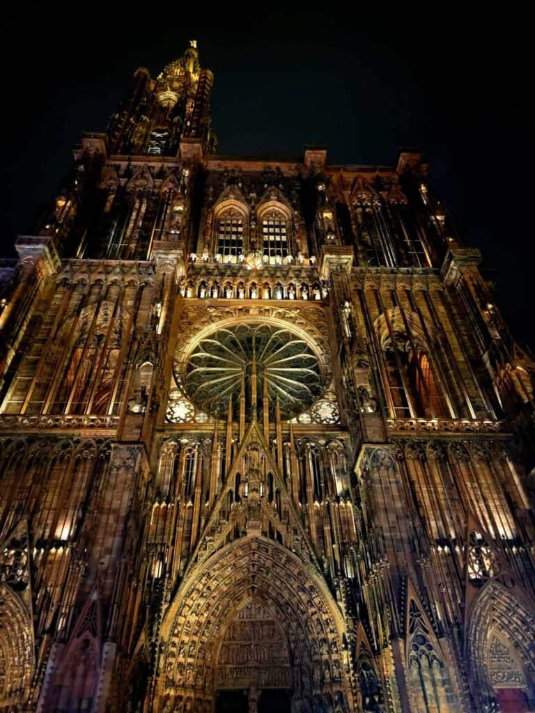 The gpthic facade of Strasbourg cathedral lit up at night