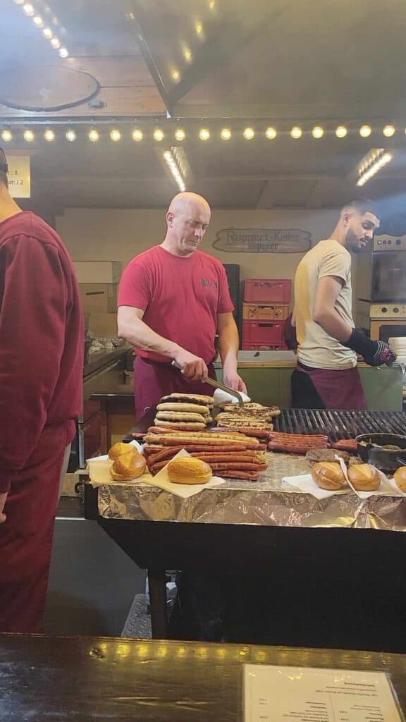 A man putting bratwurst on a bun