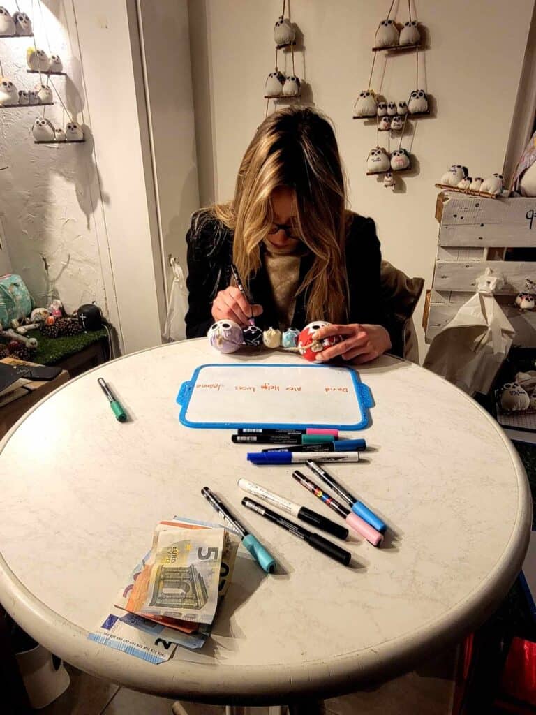 A calligrapher personalizes a set of small stuffed owls