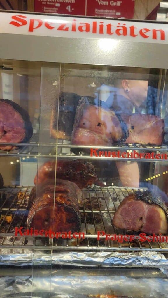 Sizzling hams behind a glass window