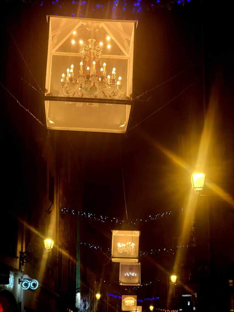 A street with a row of chandeliers in golden mesh cages