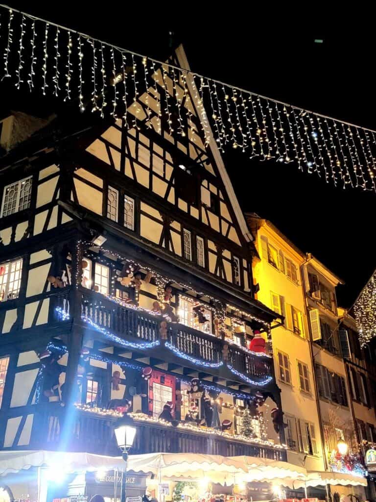 A half timbered building behind a string of icicle lights