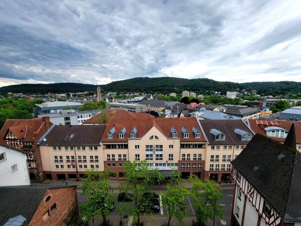 A view looking down on the Welcome Hotel Marburg with its yellowish facade and red roof