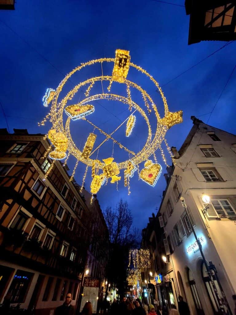 A hanging round ring with a heart and other ornaments over the street