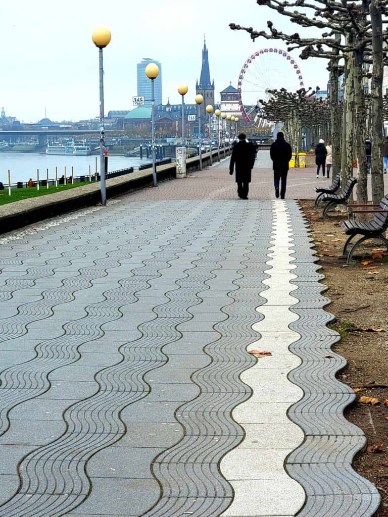 People walking on a promenade bythe river