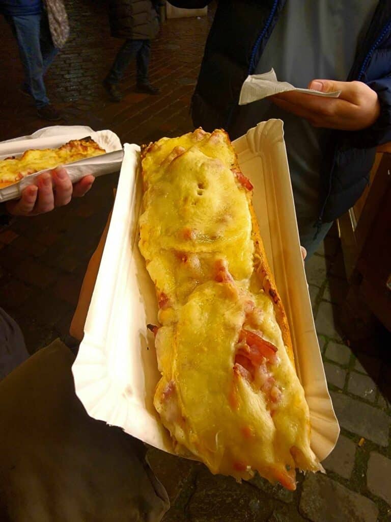 A baguette topped with bacon and cheese