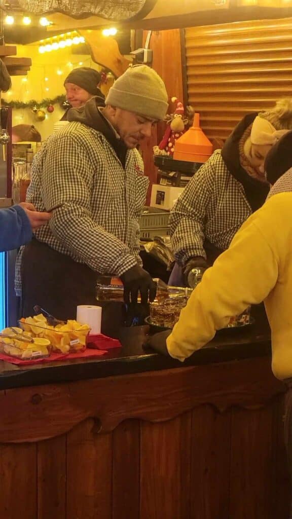 A man fills a tray with shots of schnaps