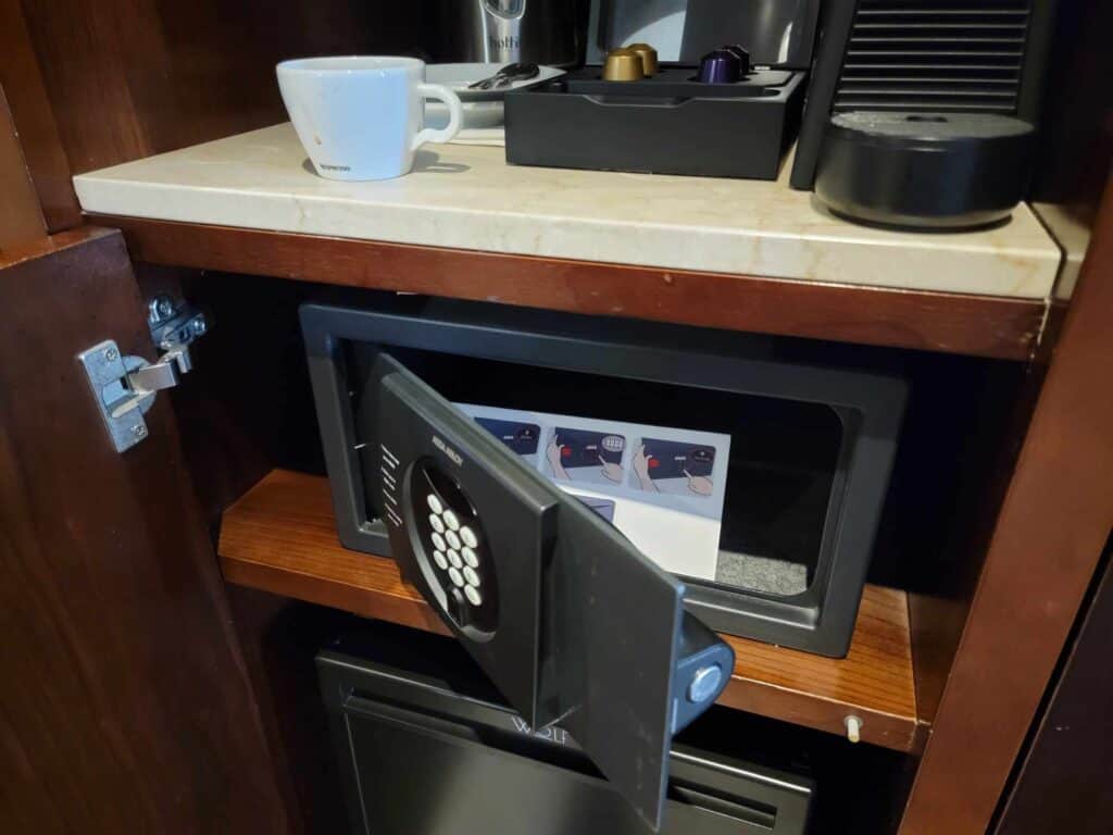 A digital combination hotel safe with the door open and instructions for use inside