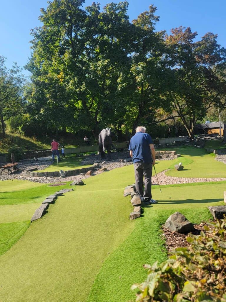 A man plays mini golf