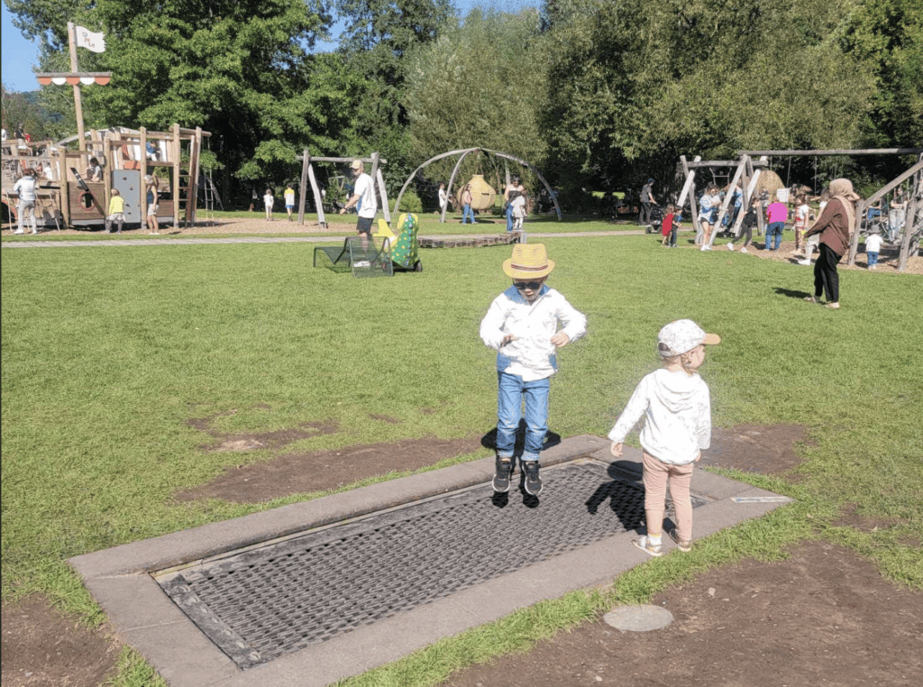 A kid jumping on a trampoline at ground level