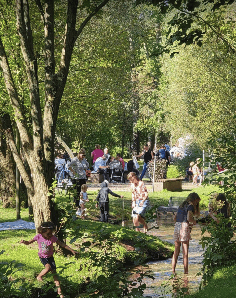 People enjoying the shallow stream, running, playing