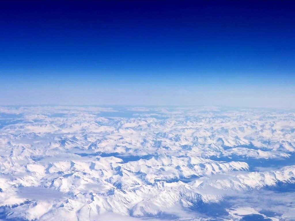 A scene out of a plane window of snow covered mountains in Alaska