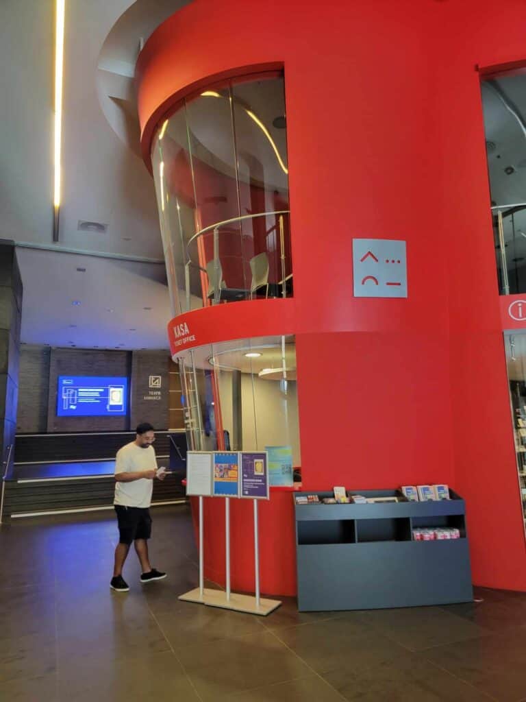 A rounded two-story red ticket booth and information center