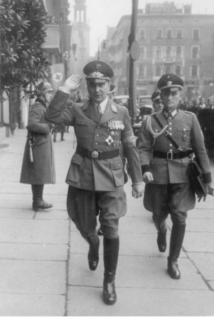 A Nazi officer giving the heil sign as he walks down the street in Poznan with another officer, a guard stands behind, and a Nazi banner with a swastika is visible