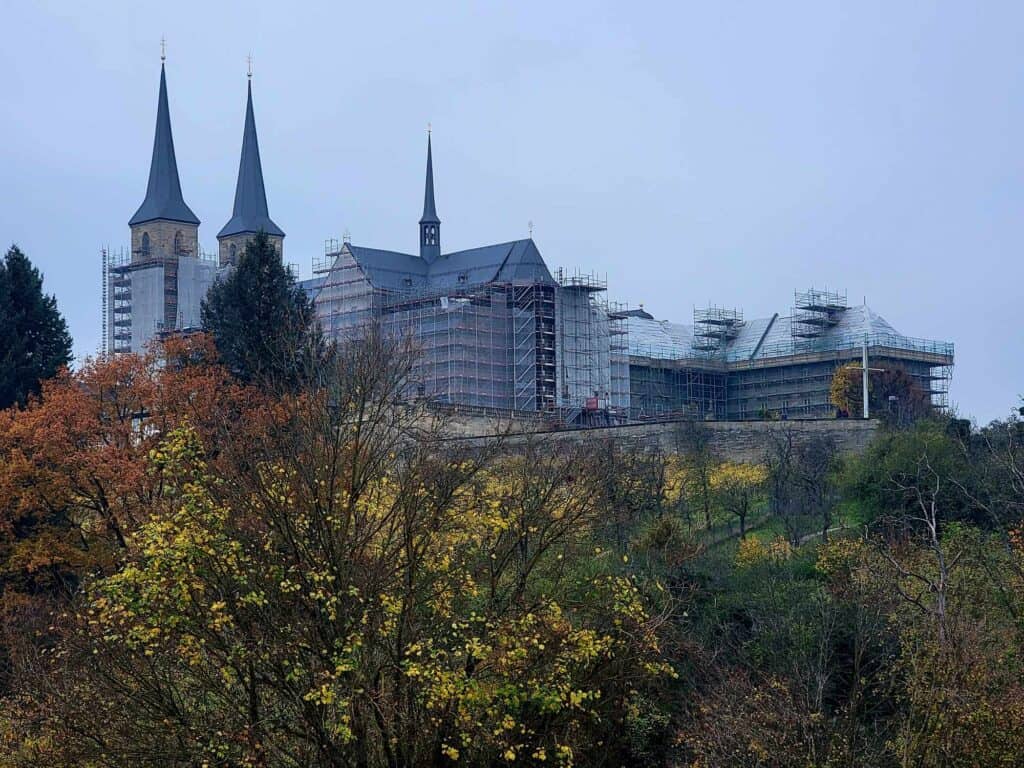 A huge building with spires completely covered by netted scaffolding