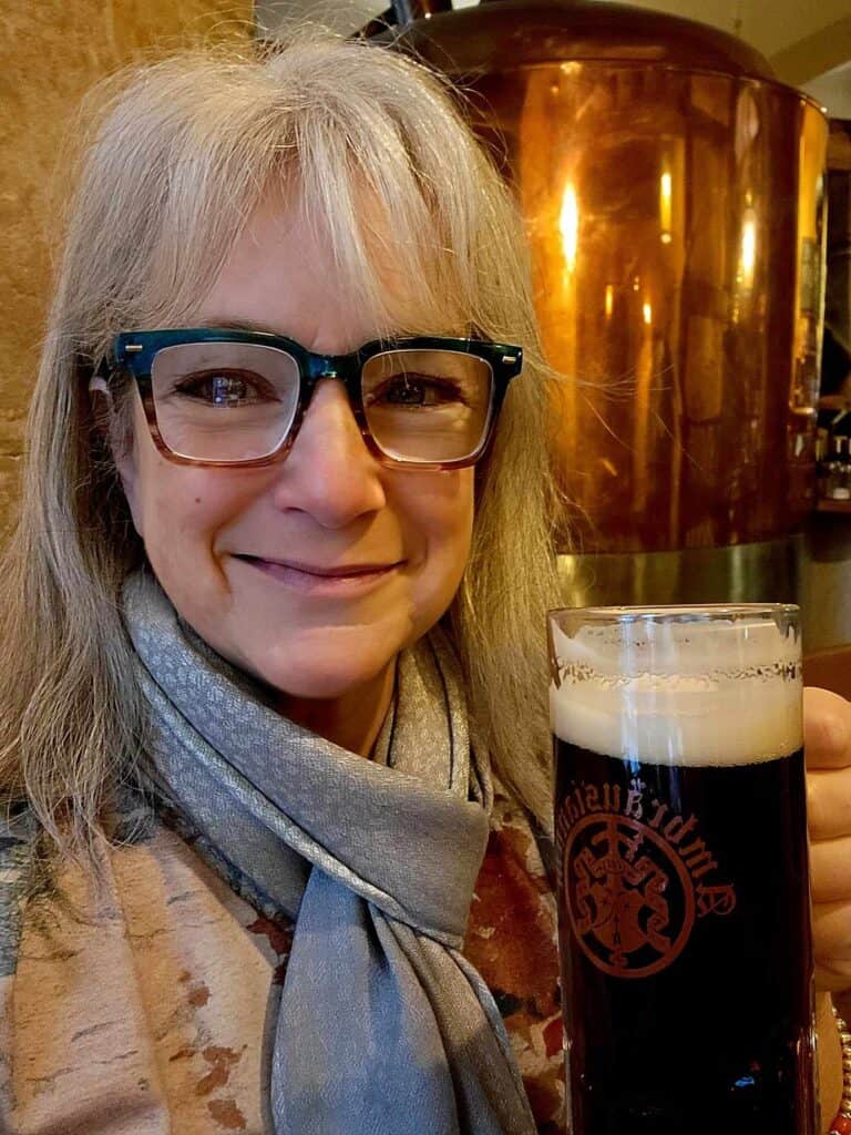 Smiling woman holding a big mug of rauchbier