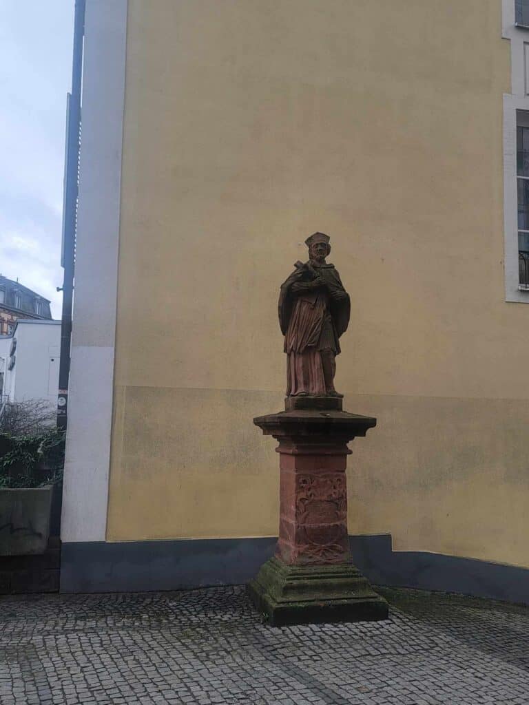 A statue of the saint of rivers stands on a pedestal