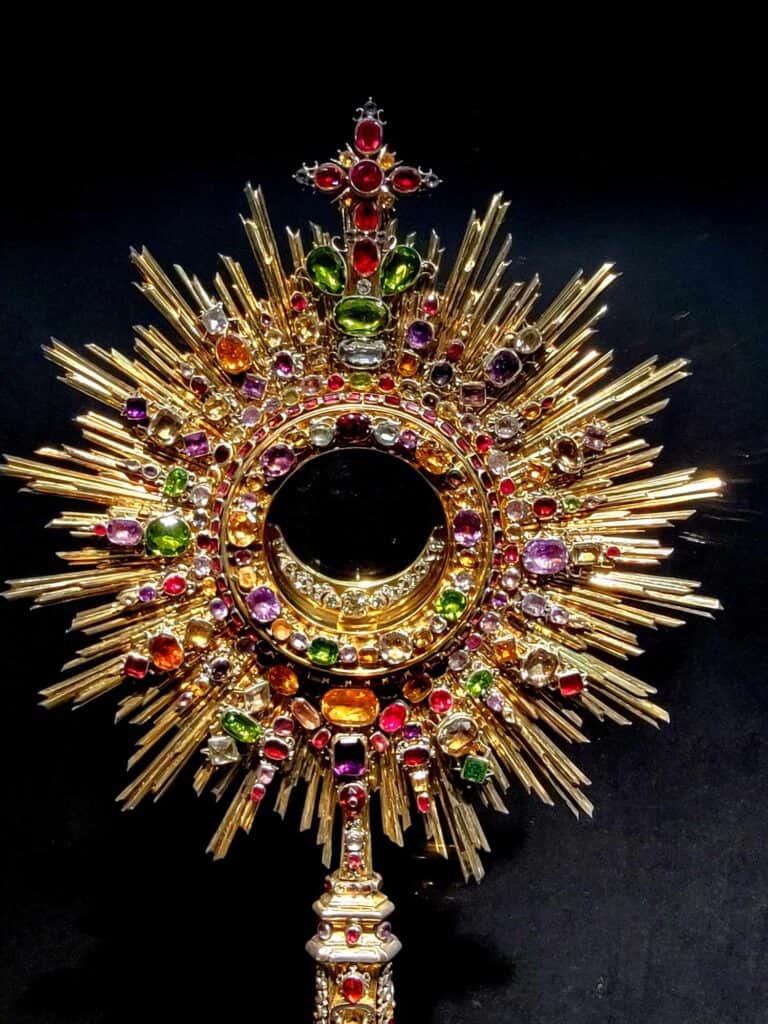 A round rayed monstrance encrusted with dozens of colorful gemstones