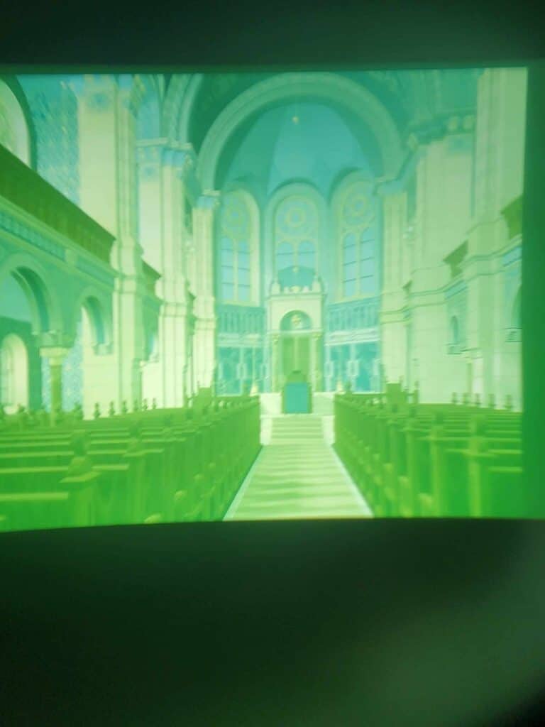 A greenish blurry image of the interior of the synagogue with high arches and pews