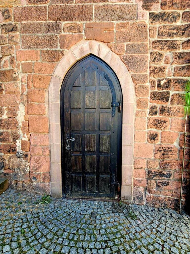 A wooden arched doorway leads into the building