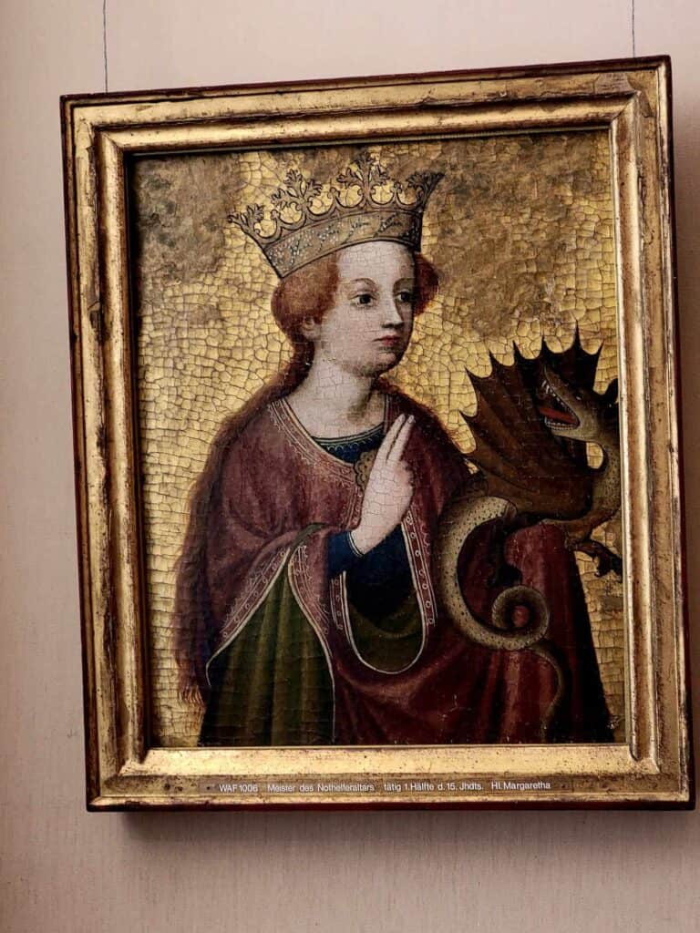 A painting of a woman in a red and green robe with a gold crown holding a poodle-sized dragon. 