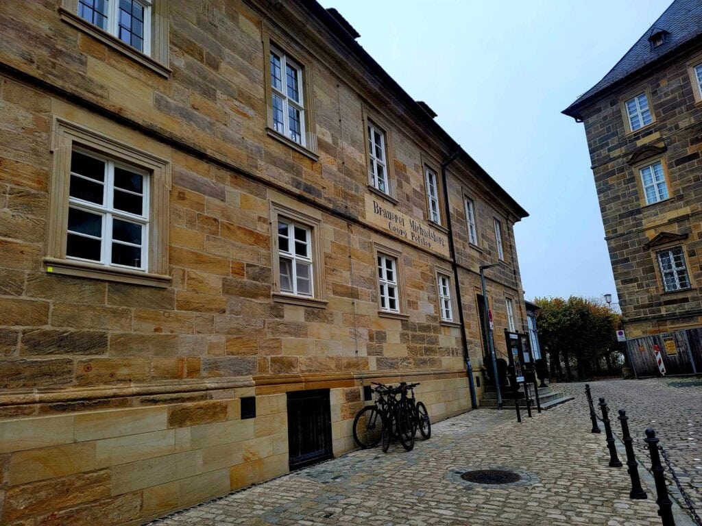 A brown stone building with bicycles leaning on it and a sign that says Brewery Museum